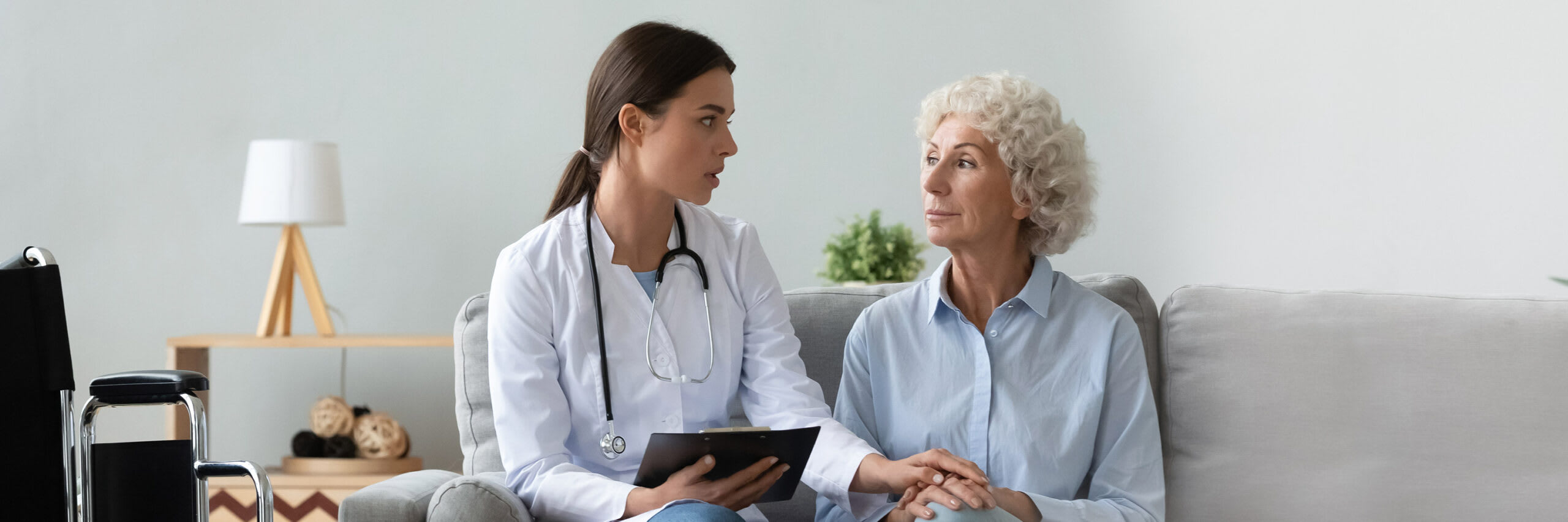 An in-home caregiver in conversation with a senior woman